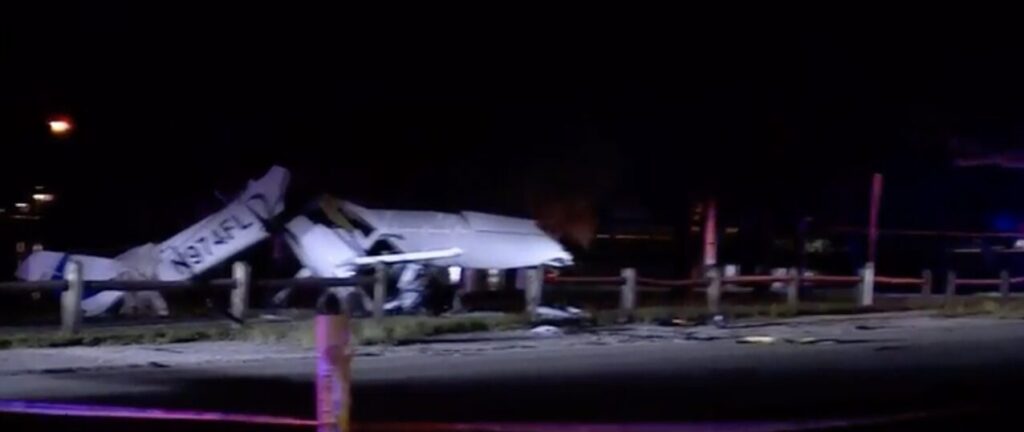 Nighttime scene of wrecked Orlican M-8 Eagle plane with tail number N974FL crashed near Lake Osborne Drive in Lake Worth Beach, Florida, after colliding with a vehicle.